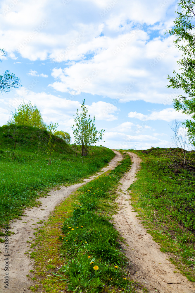 Beautiful spring landscape with a dirt road. Sunny day. Beautiful spring landscape with a dirt road. Sunny day.