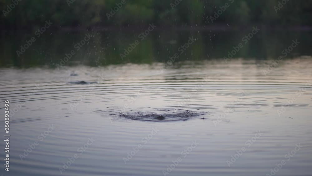 Stone skipping on water surface. Beautiful view of throwing a small flattened rock after being tossed across body of water bouncing off water many times and finally sinking in the lake. Stone skipping on water surface. Beautiful view of throwing a small flattened rock after being tossed across body of water bouncing off water many times and finally sinking in the lake.