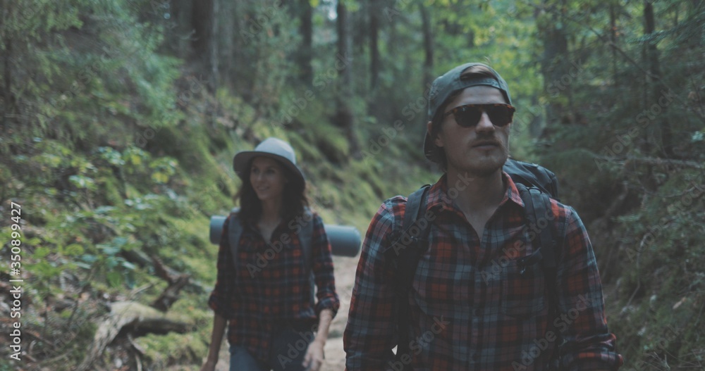Obraz premium young man and woman hiking in forest