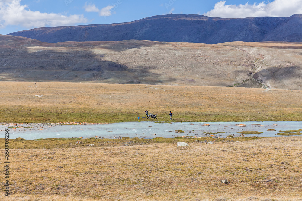 Fototapeta premium Typical view of Mongolian landscape. Mongolian steppe, Altai, Mongolia. Tourists relax near the lake.