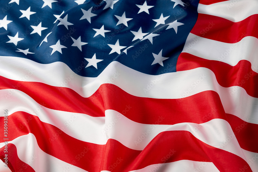 Obraz premium Close up of ruffled American flag. Satin texture curved flag of USA. Memorial Day or 4th of July. Banner, freedom concept
