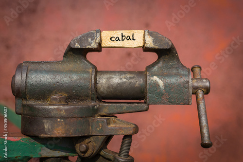 Bilde på lerret Vice grip tool squeezing a plank with the word cabal