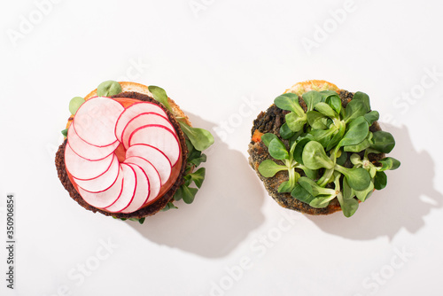 top view of vegan burgers with microgreens, radish on white background