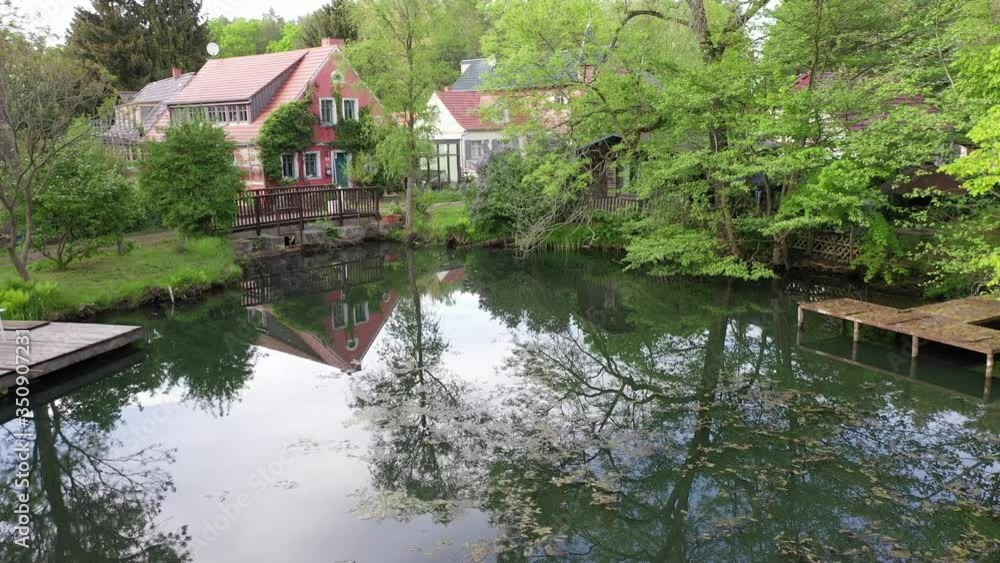 idyllic house near a forest lake nestled in a deciduous forest in spring - aerial view idyllic house near a forest lake nestled in a deciduous forest in spring - aerial view