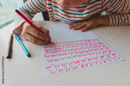 kid writing numbers, autism or asperger syndrome, mental health issues photo