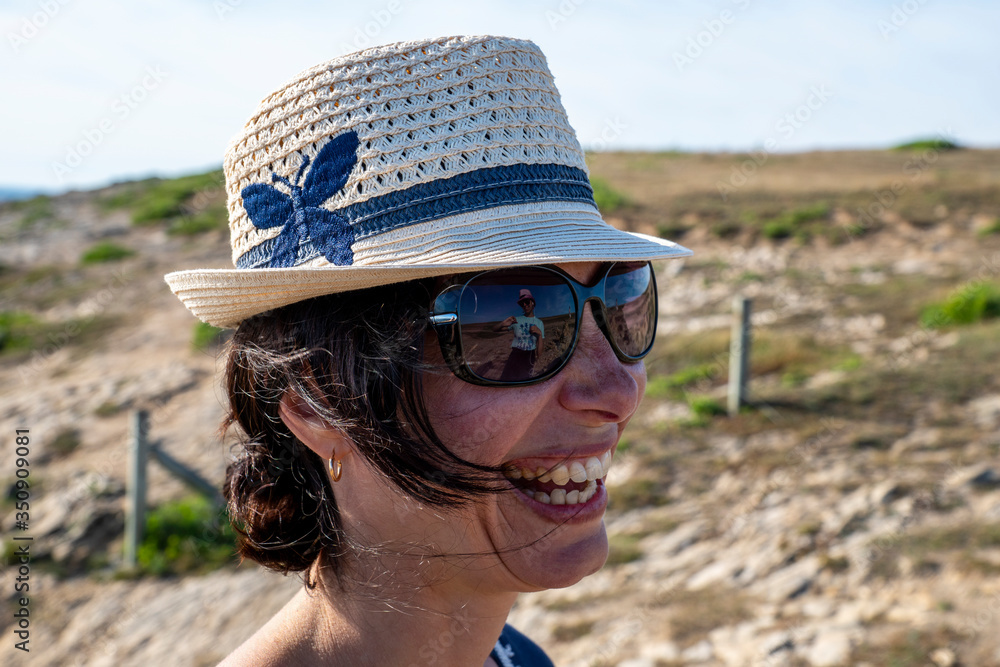 Portrait Femme Riante sur la plage. En lunettes de soleil et chapeau de  paille. Dans ses lunettes de soleil un reflet d'une fille Stock Photo |  Adobe Stock
