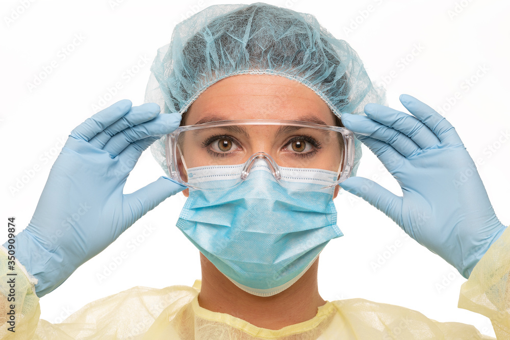 Fototapeta premium Close up of a female nurse as part of a medical team wearing personal protective equiment during covid-10 period