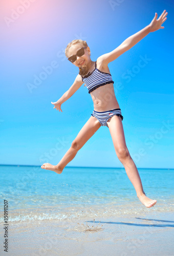 Cute little girl has fun on the beach. 