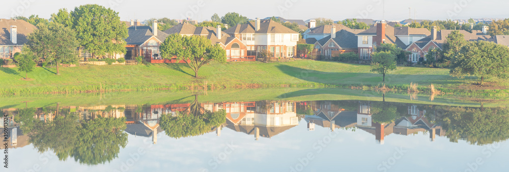 Panoramic view lakeside residential neighborhood row of houses mirror reflection near Dallas, Texas, USA