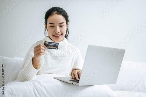 Woman playing laptop and hold a credit card.