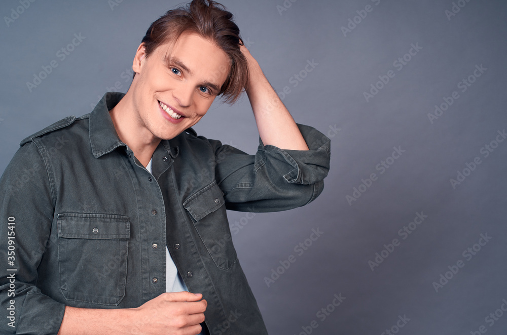 Handsome young caucasian man smiling, fashion style on gray background. Handsome young caucasian man smiling, fashion style on gray background.