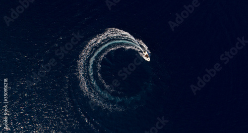 A boat is driving in a circle and produces a big whirlpool