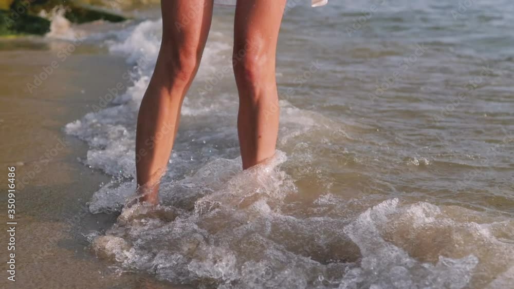 close up woman feet walking barefoot on beach at sunset leaving footprints in sand female tourist on summer vacation. close up woman feet walking barefoot on beach at sunset leaving footprints in sand female tourist on summer vacation.