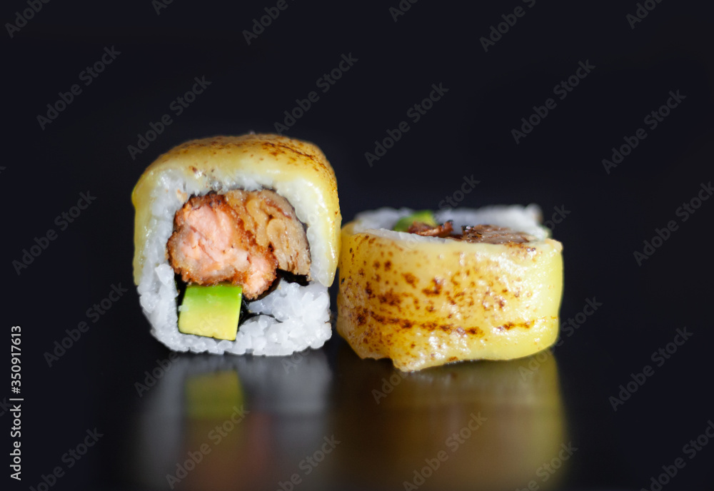Sushi roll with fried salmon, avocado and melted cheese Sushi roll with fried salmon, avocado and melted cheese