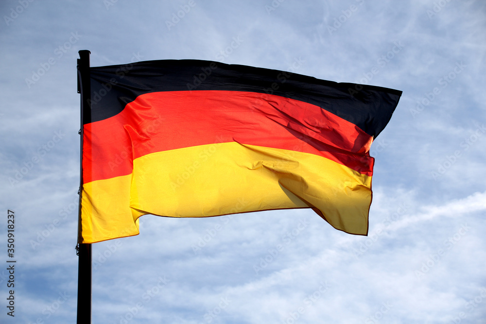 flag of the federal republic of Germany freely flutters in the wind against a blue sky, , concept of tourism, economy, politics, emigration, business flag of the federal republic of Germany freely flutters in the wind against a blue sky, , concept of tourism, economy, politics, emigration, business