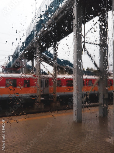 View on railway train through rainy window.