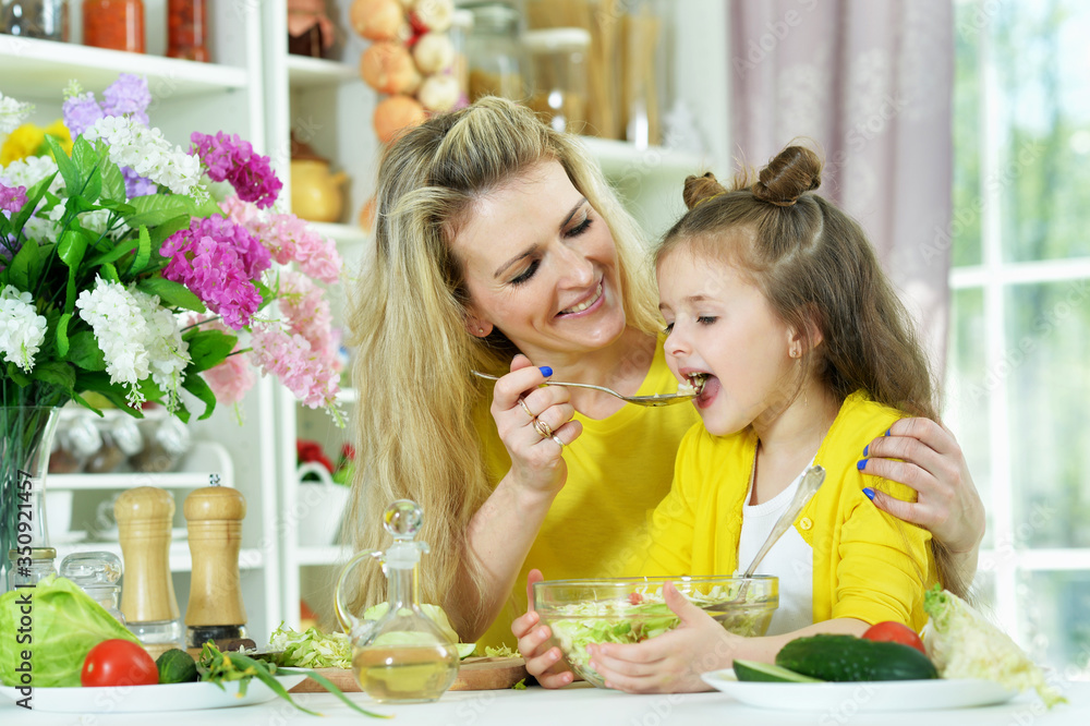 Portrait of smiling mother and daughter cooking together Portrait of smiling mother and daughter cooking together