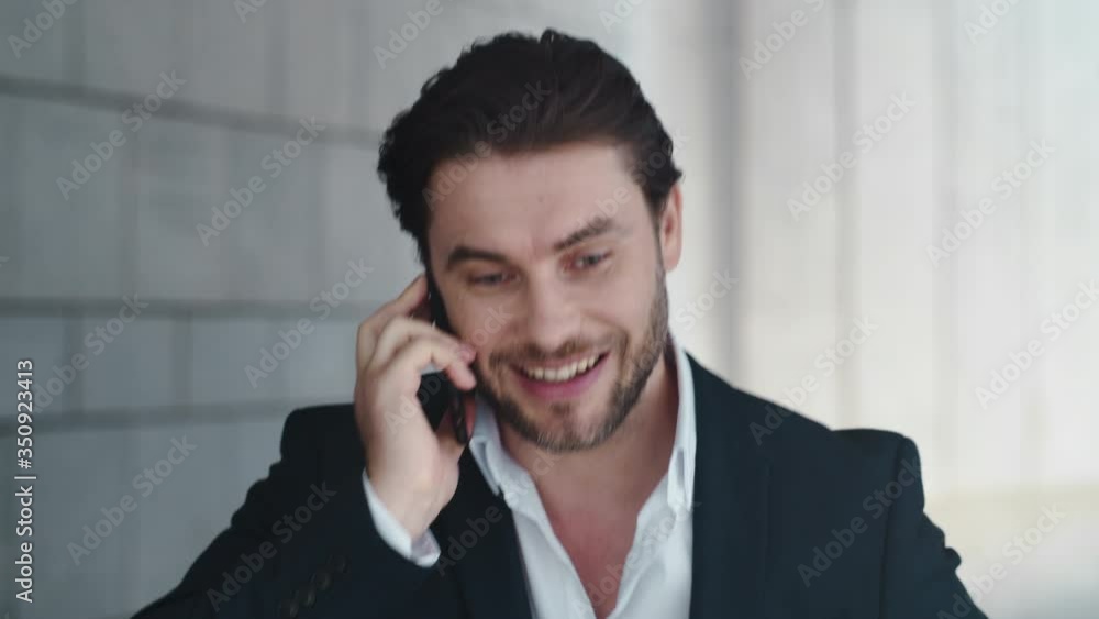 Businessman talking on cellphone with colleague outside. Man celebrating success Businessman talking on cellphone with colleague outside. Man celebrating success