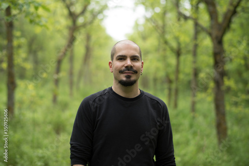 Man in forest portrait smiling and looking at camera