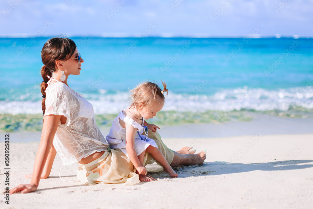 Beautiful mother and daughter on the beach enjoying summer vacation. Beautiful mother and daughter on the beach enjoying summer vacation.