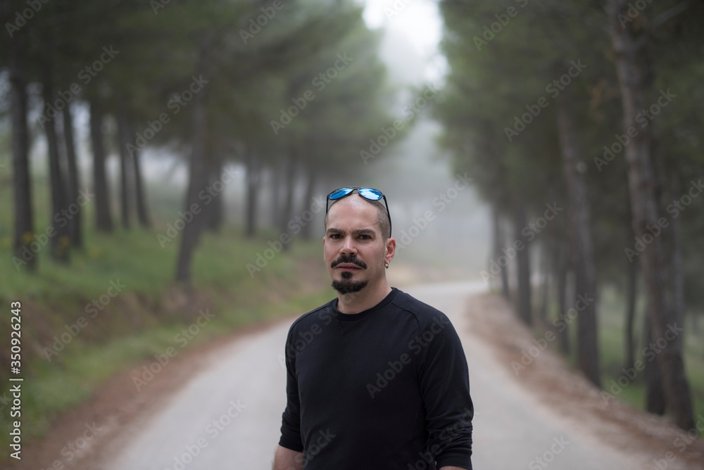 attractive bald man walks through the woods on a hike attractive bald man walks through the woods on a hike