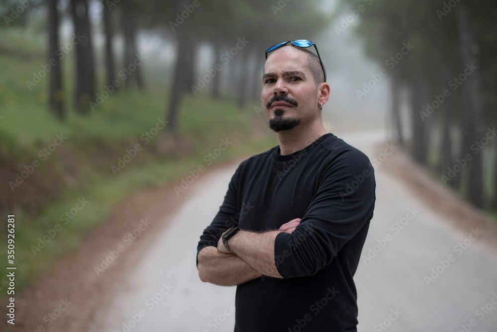 attractive bald man walks through the woods on a hike attractive bald man walks through the woods on a hike