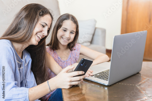 Girls at home with laptop and smartphone