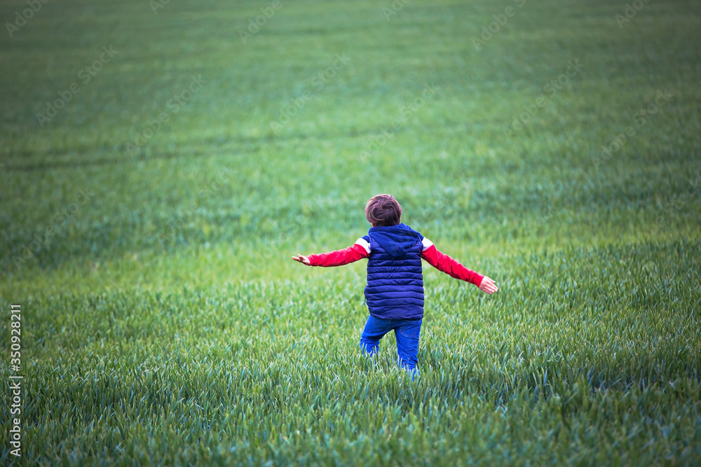 Preteen children, boys, running in green field on a cloudy day Preteen children, boys, running in green field on a cloudy day