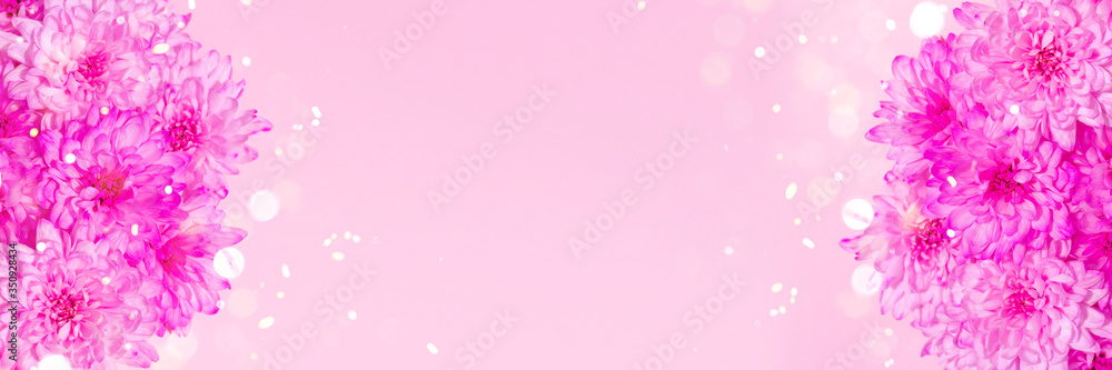Purple flowers with sparkle light on pastel pink background. Banner template for web with space for text.