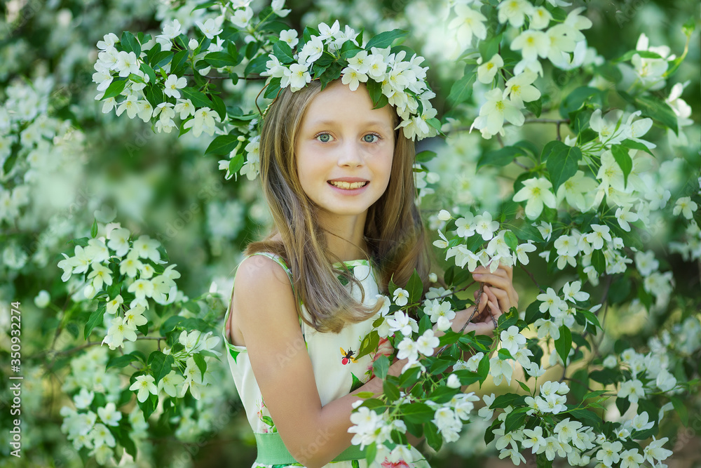 Portrait of a beautiful young long-haired girl. Adorable child having fun in blossom cherry garden on beautiful spring day. Portrait of a beautiful young long-haired girl. Adorable child having fun in blossom cherry garden on beautiful spring day.