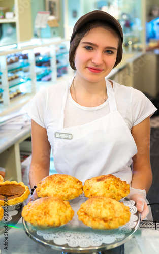 Girl with cakes at the bakery counter reflex