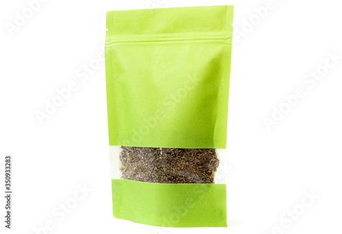 green spices and herbs packaging in paper, plain doypack standup bag filled with dry herbs with window and zipper on white background photo