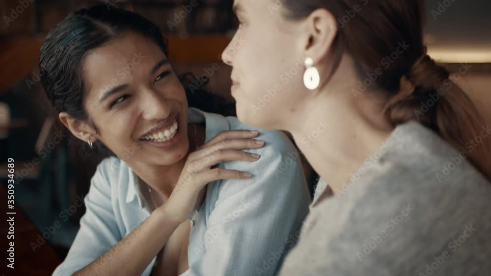 Two women talking and laughing at a coffee shop. Friends meeting at a coffee shop and chatting.
Two women talking and laughing at a coffee shop. Friends meeting at a coffee shop and chatting.