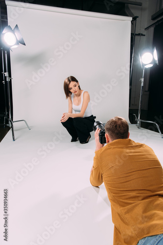 Attractive model posing while working with photographer in photo studio