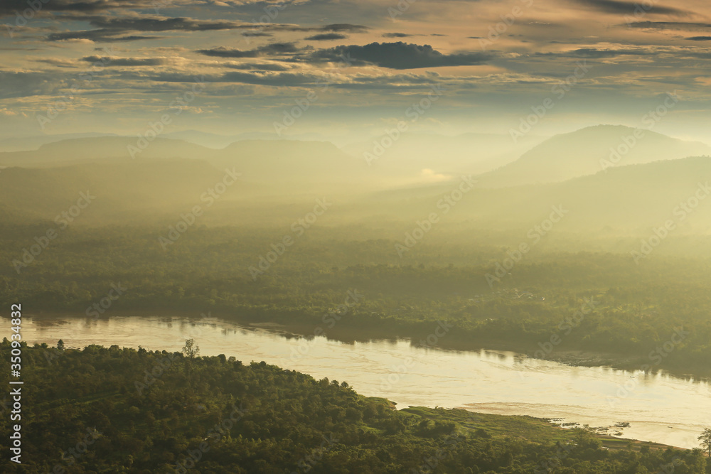 Panorama viewpoint at Pha Chanadai has thick fog in the morning. See the sun shine through the mountain peaks of Laos