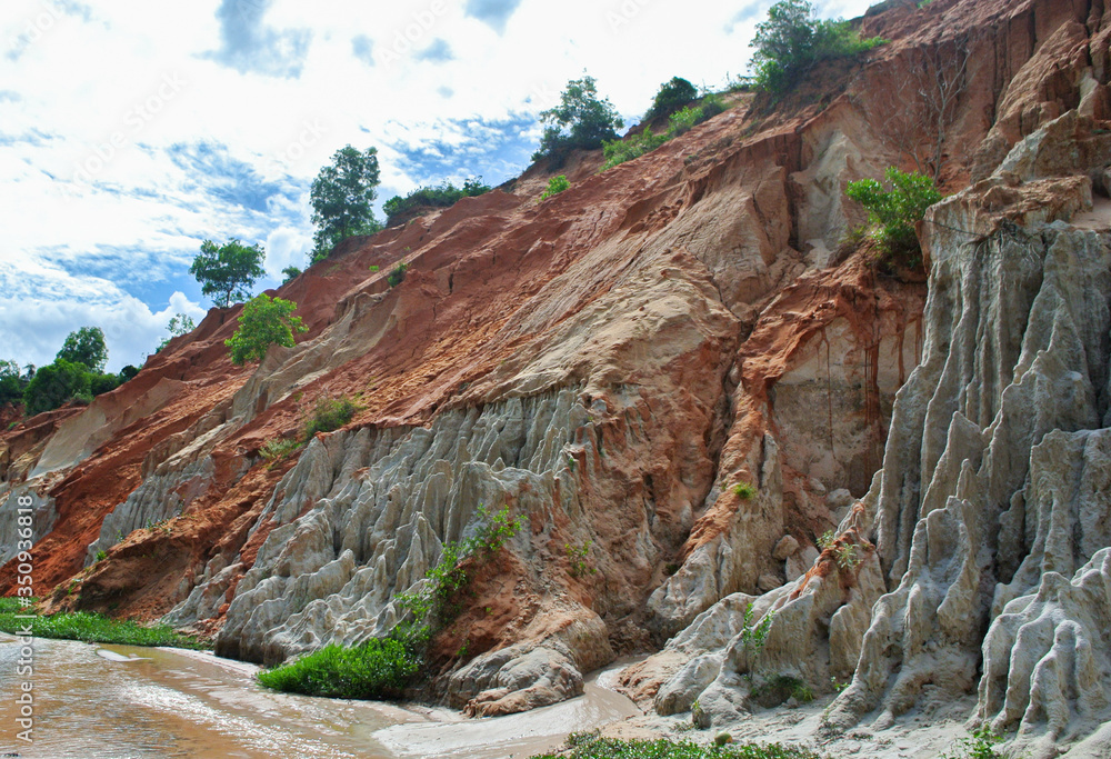 Geological weathering and erosion of red and white sand layer.Earth processes
