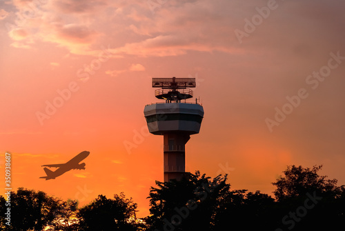 Silhouette of  radar tower and airliner with twilight sky at sunset time