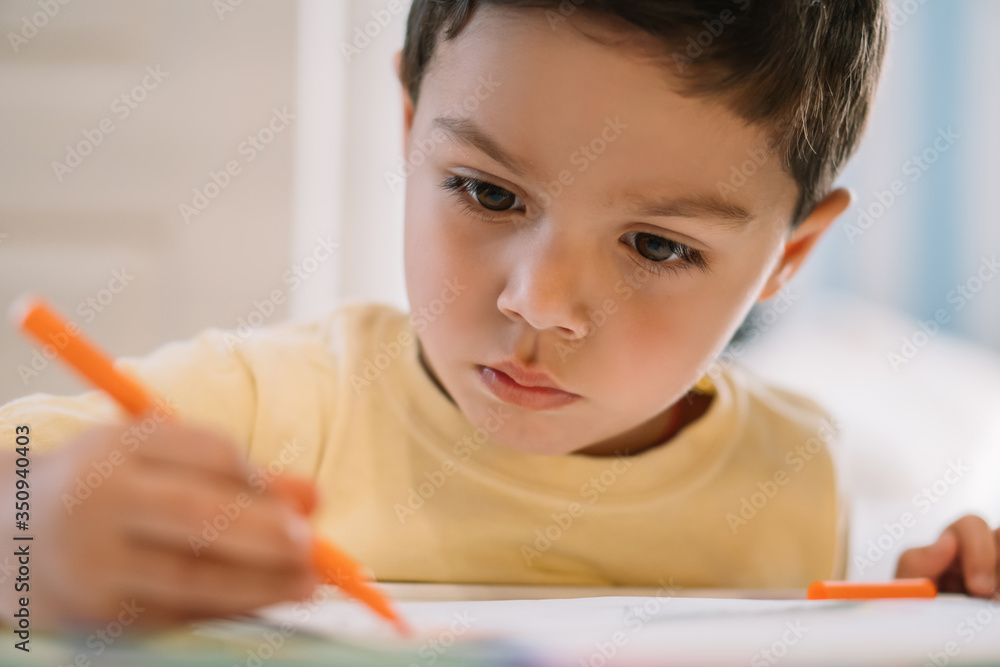 selective focus of adorable, concentrated boy drawing with felt pen selective focus of adorable, concentrated boy drawing with felt pen