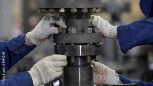 Oil and Gas Wellhead tree equipment production plant. Worker assembles of wellhead fitting. Modern tendencies of machine engineering. Equipment for wellhead conncetion of oil and gas wells.