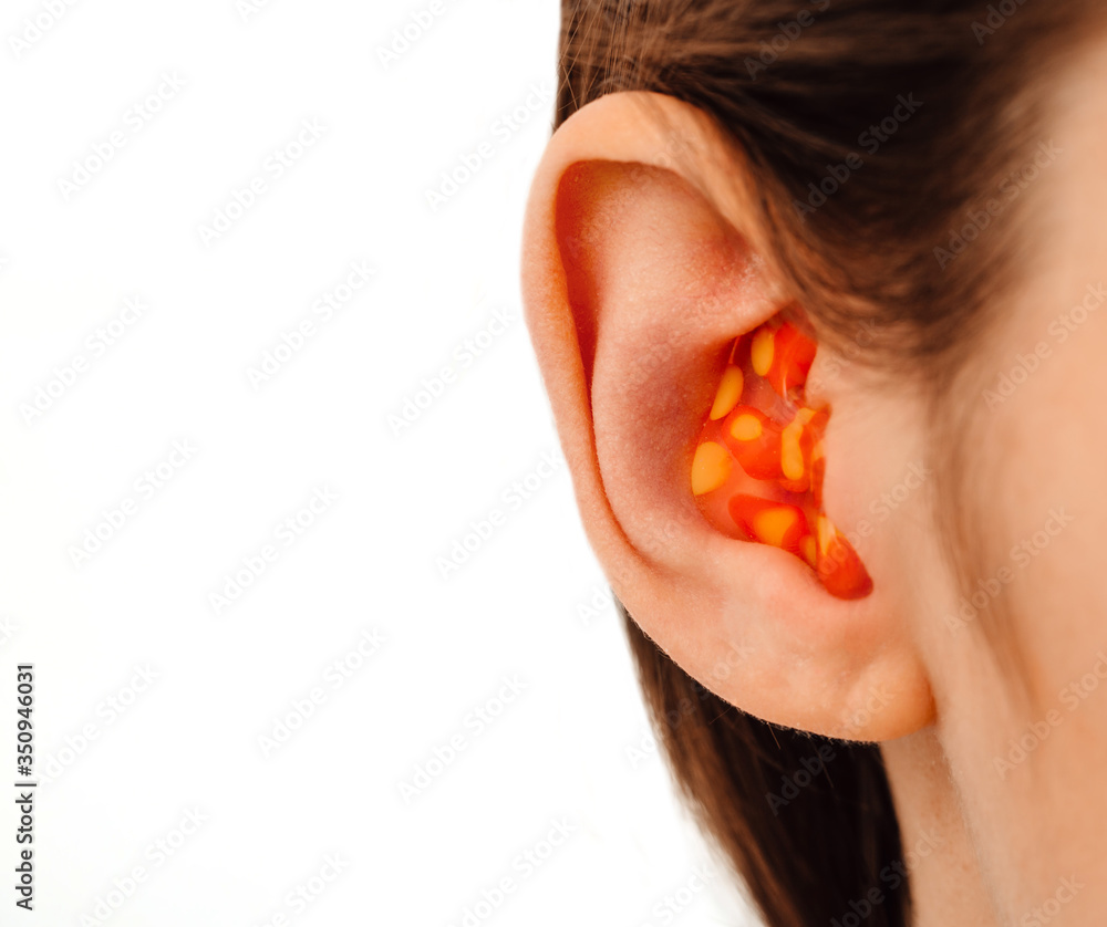 earplugs for noisy places, personally molded earplugs on ear close-up, isolated on white earplugs for noisy places, personally molded earplugs on ear close-up, isolated on white