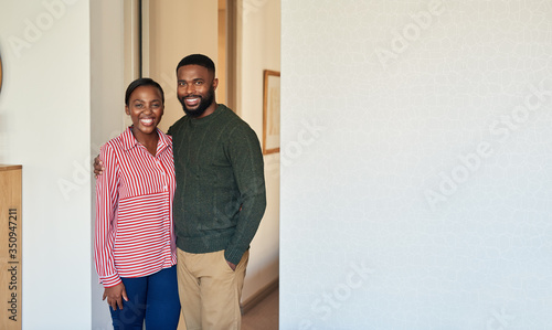 Smiling young African American couple standing together at home