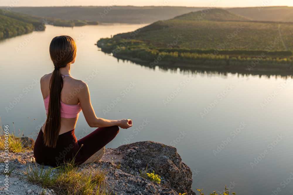 Sport girl doing yoga in mountains beautiful landscape. Young woman leads healthy lifestyle, meditates