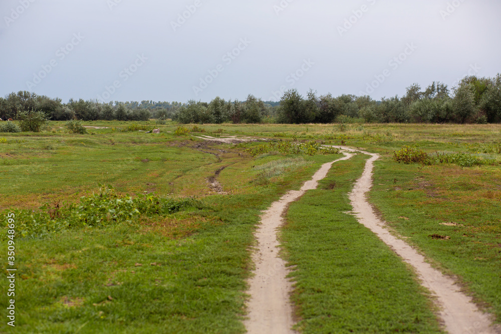 Rural country road in the field. Track from the car wheels. Rural country road in the field. Track from the car wheels.