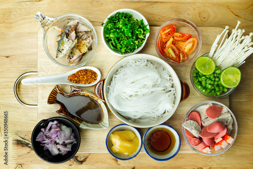 Lightly fermented rice noodles mix spicy have ingredients around on wood floor top view angle