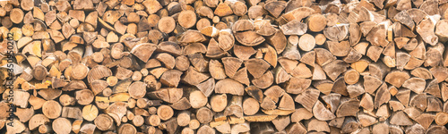 panorama. pattern of firewood. light wooden background