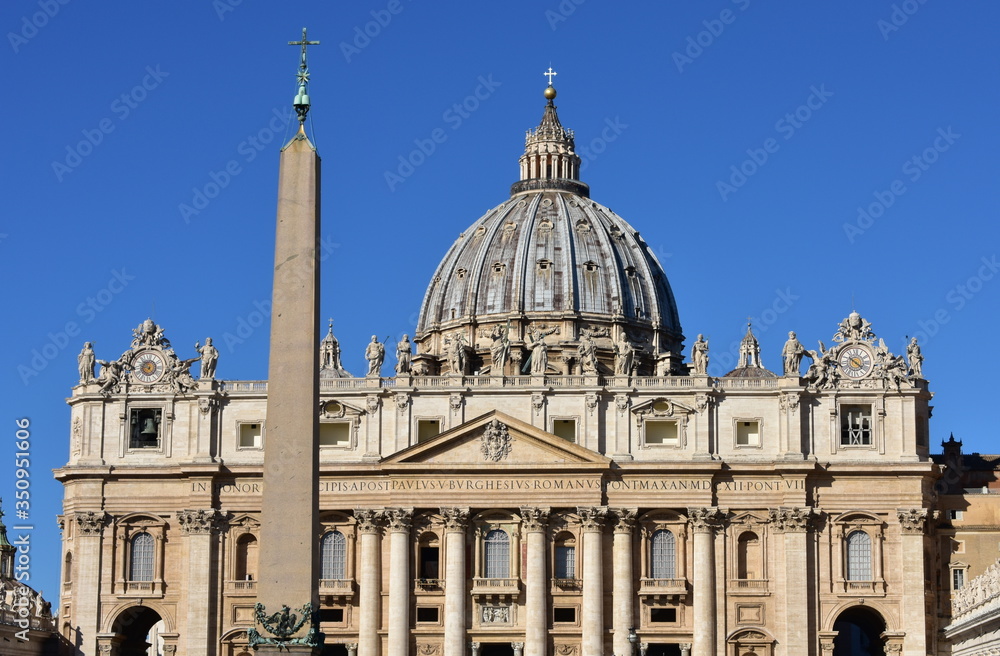 St. Peter’s Basilica and the ancient egyptian Obelisk at the St. Peter’s Square with blue sky. Vatican City, Rome, Italy.