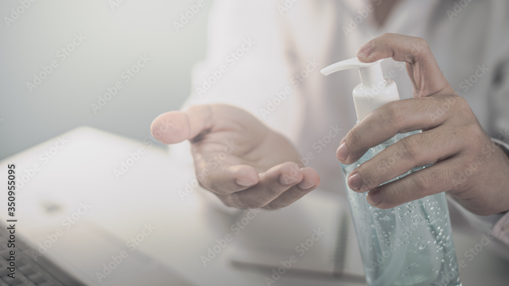 Business man washing his hands with an alcohol gel in a pump-like bottle to prevent the spread of the Covid-19 virus. Business man washing his hands with an alcohol gel in a pump-like bottle to prevent the spread of the Covid-19 virus.