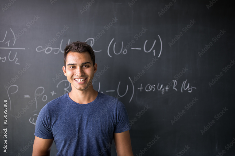 Students in a classroom - handsome student solving a math problem on a blackboard during math class - obrazy, fototapety, plakaty 