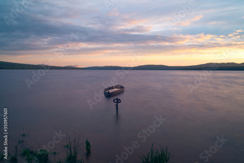 The view of the sunset and boats on the lake Zuratkul