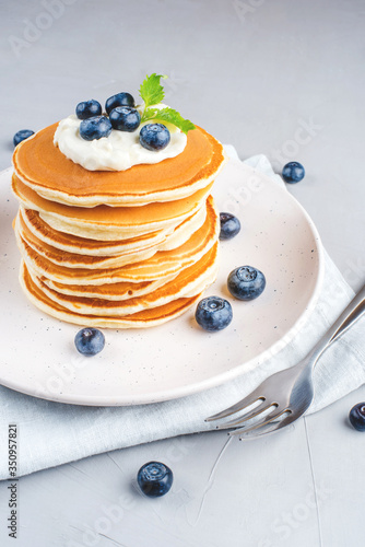 A stack of pancakes with fresh blueberries and cheesecream. photo